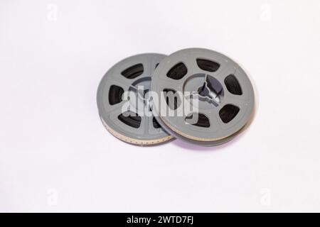 Selective focus, close up on two old school 8mm film reels against a white background. Stock Photo