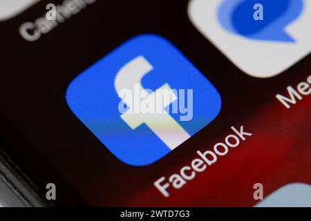 Facebook app icon on mobile phone Stock Photo
