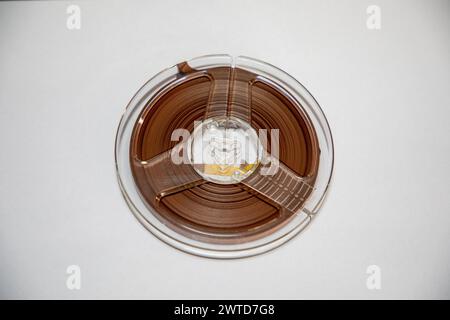 Close up on an old school audio reel to reel tape against a white background . Stock Photo