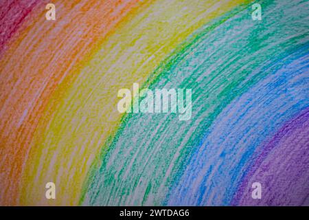 Colorful chalk rainbow drawing on paper surrounded by crayons Stock Photo