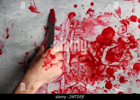 Bloody female hand on a grey background with copy space, close-up photo of a hand covered in blood. Abuse domestic violence concept. Stock Photo