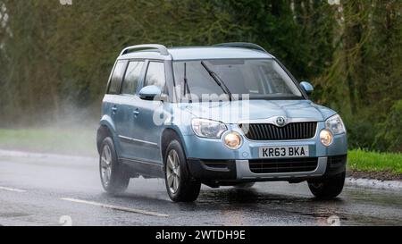 Milton Keynes,UK-Mar 17th 2024: 2013 blue Skoda Yeti car driving in the rain Stock Photo