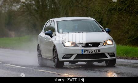 Milton Keynes,UK-Mar 17th 2024: 2016 white Seat Ibiza car driving in the rain Stock Photo