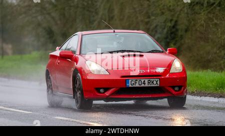Milton Keynes,UK-Mar 17th 2024: 2004 red Toyota Celica car driving in the rain Stock Photo