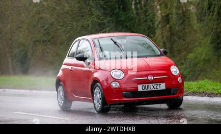 Milton Keynes,UK-Mar 17th 2024: 2011 red Fiat 500 car driving in the rain Stock Photo