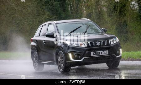 Milton Keynes,UK-Mar 17th 2024: 2019 black Suzuki Vitara car driving in the rain Stock Photo