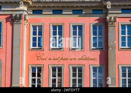 It looks like a castle, but it's not, and that's what it says. Behind the seemingly historic walls of the old Potsdam City Palace lies the ultra-modern building of the Brandenburg State Parliament. The Brandenburg state parliament is located behind the restored façade of the Potsdam City Palace. Artist Annette Paul has added the words "Ceci n'est pas un château" in gold letters as an ironic distancing from the first impression the building gives, quoting René Magritte's painting of a tobacco pipe entitled "ceci n'est pas une pipe". Potsdam, Brandenburg, Brandenburg, Germany Stock Photo