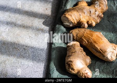 Raw organic ginger roots on textile napkin in sunny day Stock Photo