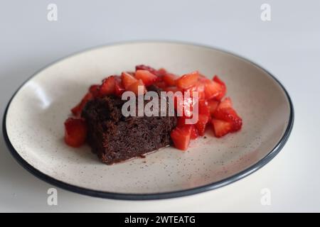 Chocolate brownies. Indulge in decadent chocolate brownies paired with fresh strawberries, perfect for dessert lovers, food bloggers, and culinary ent Stock Photo