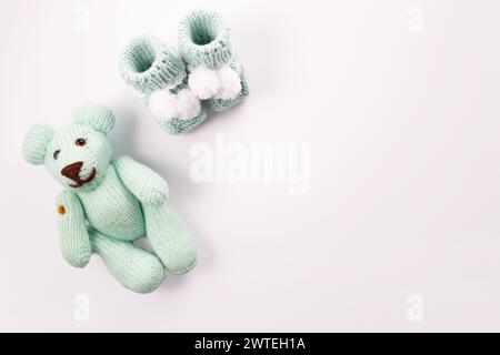 Baby socks and teddy bear on white background. Baby boy birth. Greeting card.Pregnancy announcement. Flatlay, top view Stock Photo