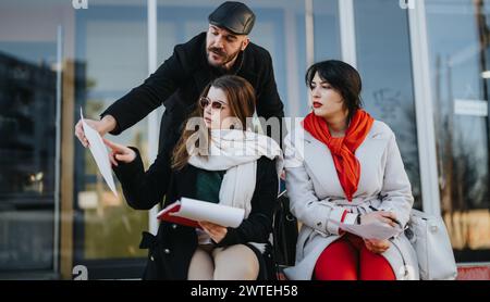 A group of young business entrepreneurs engaged in an outdoor meeting, brainstorming strategies for success in a bustling urban city environment. Stock Photo