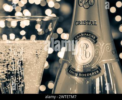 CRISTAL CHAMPAGNE RETRO VINTAGE SEPIA B&W STYLE Bottle and freshly poured glass of Louis Roederer Cristal luxury fine champagne with sparkling lights in background. Stock Photo