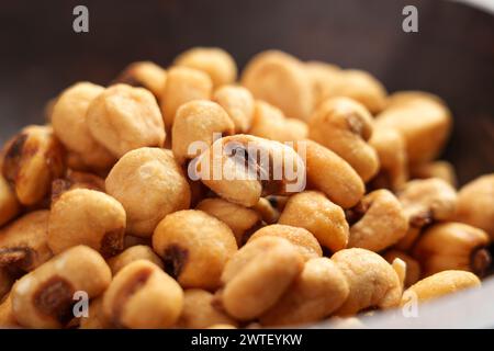 Organic salty roasted dried maize grains in wooden bowl close up. Tasty beer snack of fried corns Stock Photo