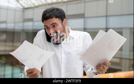 Smiling mature businessman holding a smartphone in an office. High quality photo Stock Photo