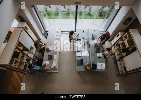 High-angle view of a modern office space with working business teammates. Stock Photo