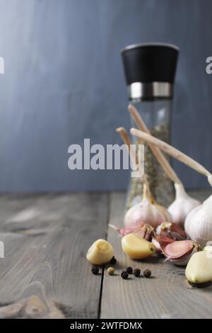 Peeled garlic and heads of white purple garlic on gray foon with space for salt shaker text Stock Photo