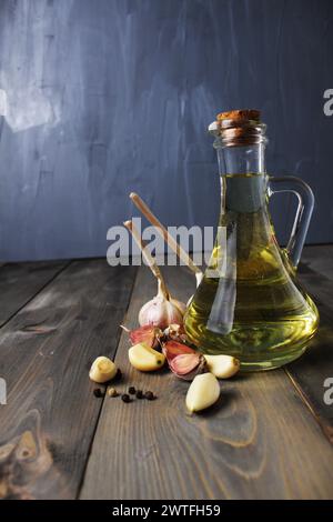 Fragrant vegetable oil with garlic and black red pepper on grey background with space for copy space text Stock Photo