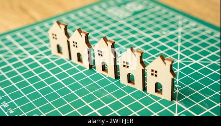 Miniature houses on a cutting mat. Home renovation and reconstruction concept. Construction of real estate and new housing. Maintenance house. Close u Stock Photo