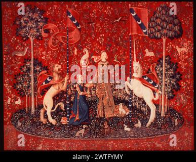 Taste. unknown c. 1490-1500 Tapestry Dimensions: H 12' x W 10'6' Tapestry Materials/Techniques: wool & silk Culture: Southern Netherlands Ownership History: Boussac Château, near Aubusson. Acquired by the Cluny Museum, 1882. France, Paris, Paris, Musée de Cluny, accno. Cl. 10831. Richly gowned lady choosing sweets from bowl, parakeet holding sweet in claws & monkey putting sweet in mouth, lion & unicorn holding banner & standard of Le Viste family (gules, band azure with 3 crescents of argent), dark blue oval island & red background with millefleurs motif The 'Lady with unicorn' series may hav Stock Photo