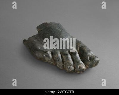 Sculpture Fragment: Right Foot from a Male Statue. Unknown late 2nd–3rd century A.D. A hollow cast bronze right foot from a male statue. Preserved are five toes and the front part of the foot. The bottom of the foot and toes is completely cut out. The large toe is shorter than the index; the other toes curl against each other to the right except the small toe, which curves to the left. Stock Photo