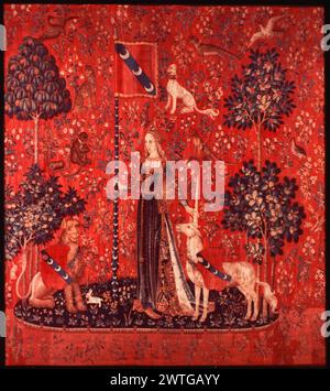 Touch. unknown c. 1490-1500 Tapestry Dimensions: H 12' x W 10'2' Tapestry Materials/Techniques: wool & silk Culture: Southern Netherlands Ownership History: Boussac Château, near Aubusson. Acquired by the Cluny Museum, 1882. France, Paris, Paris, Musée de Cluny, accno. Cl. 10835. Richly gowned lady holding unicorn's horn with left hand & Le Viste family standard with right hand (gules, band azure with 3 crescents of argent), (L) lion, dark blue oval island & red background with millefleurs motif The 'Lady with unicorn' series may have been commissioned by Jean IV Le Viste (d. 1500). It was res Stock Photo