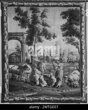 Dial. Huet, Jean-Baptiste (French, 1745-1811) (designed after) [painter] c. 1780-1810 Tapestry Dimensions: H 8'8' x W 7'6' Tapestry Materials/Techniques: unknown Culture: French Weaving Center: Aubusson Ownership History: French & Co. purchased from Mrs. Elizabeth M. Godwin, received 5/7/1946; sold to V. C. [Vigo & Charles] Sternberg 9/19/1962. In landscape with arched gateway & buildings (L), trees & plants, a group of men & women with children gathered around a sun dial & flanked by cattle grazing; arched bridge in distance (R) (BRD) pole with garland spiral This tapestry is often seen as th Stock Photo