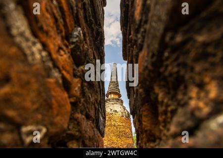 Ayutthaya temple framed by a narrow gap in red brick walls. Stock Photo