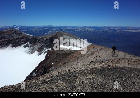 Tourist stands on edge of volcano Puyehue crater, Puyehue National Park, Chile Stock Photo
