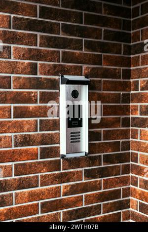 Modern intercom device at residential building entrance door with camera and dial keypad lock, selective focus Stock Photo