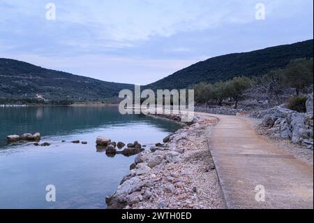 Path and calm sea near Cres Croatia after sunset in springtime Cres Croatia Stock Photo