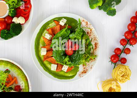 Salad of pumpkin, spinach, feta cheese and cherry tomatoes. Topped with sauce. Keto diet. Copy space Stock Photo