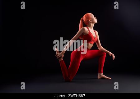 Young woman practicing yoga against black background Stock Photo