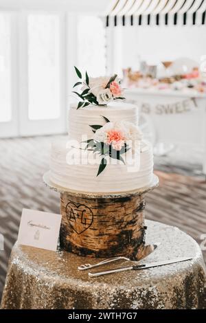 white wedding cake with big flowers on rustic stand Stock Photo
