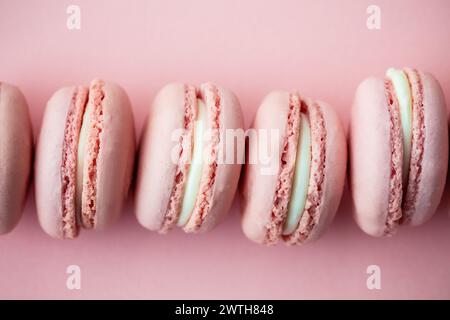 Soft pink macarons perfectly lined up on a matching background Stock Photo