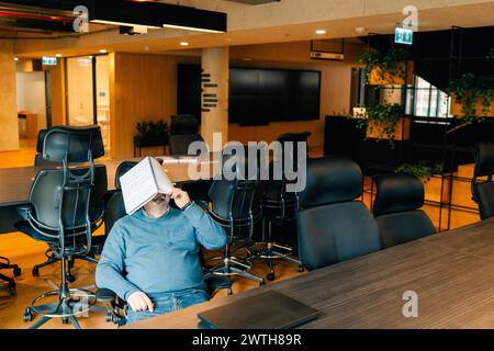 man is tired of working at the computer and is resting at workplace Stock Photo