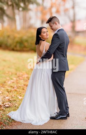 Bride looking into the camera over her shoulder with the groom Stock Photo