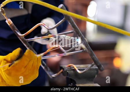 Copper pipes gas welding with filler wire. Selective focus. Stock Photo