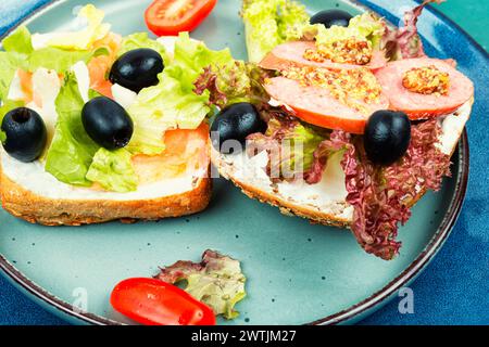 Homemade sandwiches with trout fish and sausages for breakfast. Fast food. Open toasts. Stock Photo