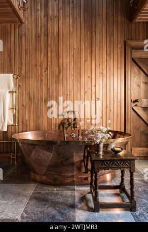 Brass freestanding bathtub with wood cladding in in luxury hotel in Ardfin on the Isle of Jura, Inner Hebrides, Scotland, UK Stock Photo