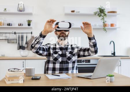 Caucasian worker testing VR headset while sitting at wooden table. Stock Photo