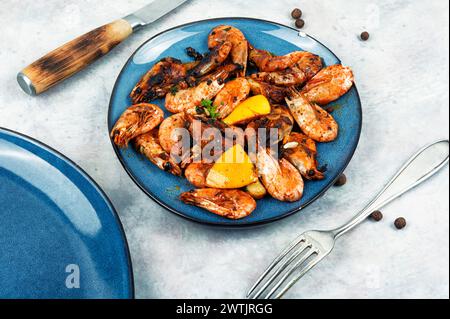 Fried unpeeled shrimp on a plate. Roast prawns shrimps. Stock Photo
