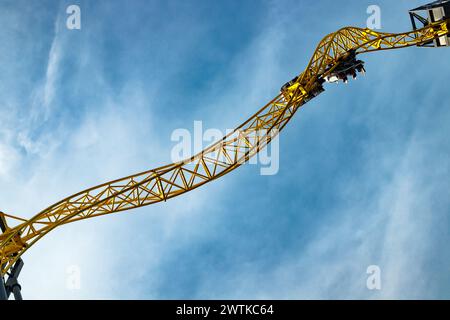 Ride roller coaster in motion in amusement park on blue sky background. Stock Photo