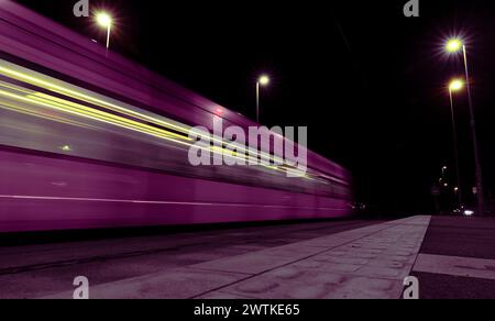 Train moving past quickly at night. Stock Photo