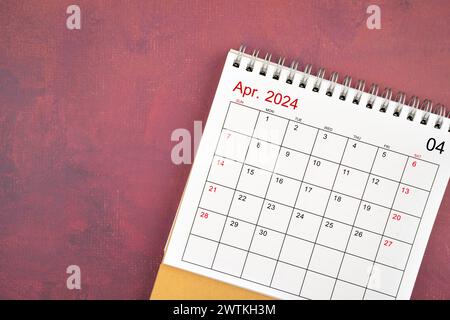 April 2024 desk calendar on red color background. Stock Photo