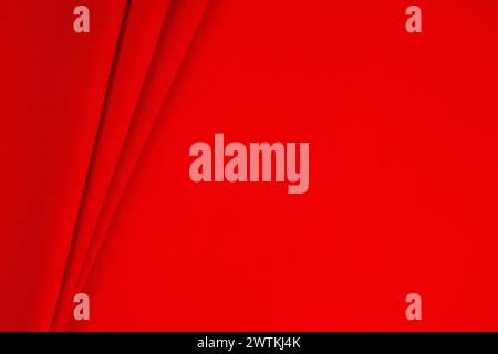 Red satin background. Wavy soft folds on fabric. Luxurious dark red background. Stock Photo
