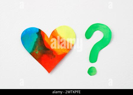 Multicolored heart questioned by question mark Stock Photo
