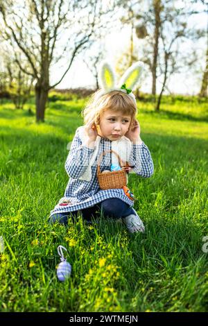 Easter tradition comes alive as children playfully search for hidden eggs, their baskets filling with painted symbols of joy. Stock Photo