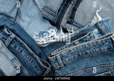 Background of stacked jeans. Texture of scattered jeans Stock Photo