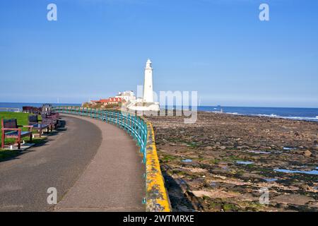 St Marys Lighthouse viewed from the promenade at low tide across the causeway. Stock Photo