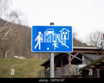 German living street sign in a residential district. Traffic symbol to be aware of playing children on the road. Speed limit zone to ensure safety. Stock Photo